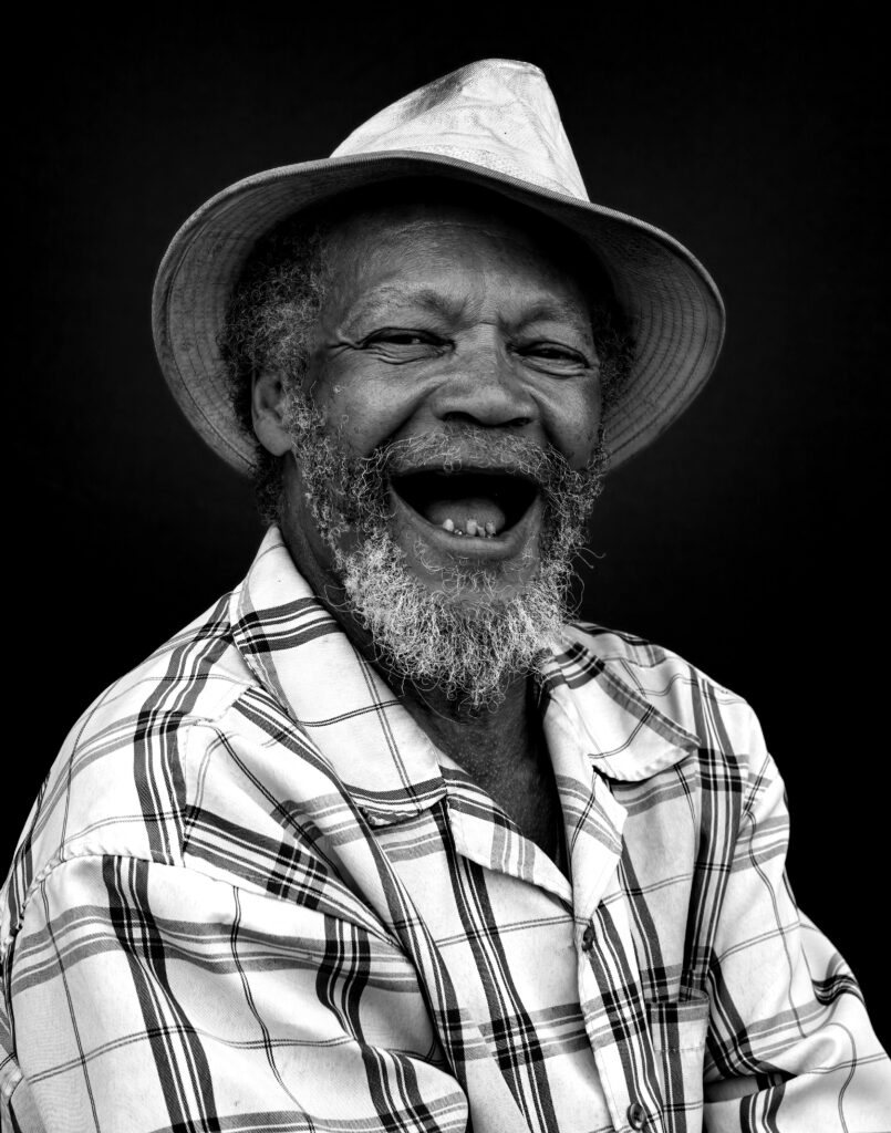 Portrait of a cheerful senior man with a hat, expressing joy and laughter in Milwaukee.